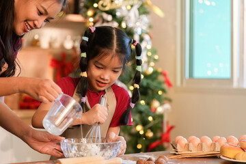 Whisking Together A mother and daughter preparing holiday treats in a festive kitchen
