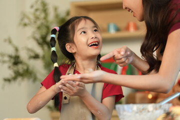 Mother and Daughter Sharing Joyful Moments While Baking Together