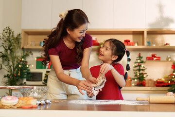 Baking Together: A joyful mother and daughter making holiday cookies in a festive kitchen