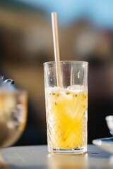 A refreshing passion fruit cocktail sits on a table in Porto, Portugal, offering a bright yellow hue and inviting straw, perfect for a warm afternoon under the sun
