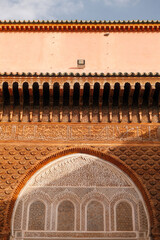 Red-brown Moroccan wall featuring intricate geometric patterns and detailed craftsmanship, showcasing traditional Islamic architecture and cultural design elements under natural light.