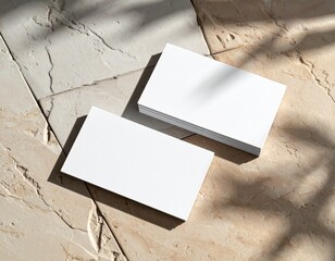 Business card mockup on textured surface with natural shadows, premium printing finish (matte or gloss), top-down photography style