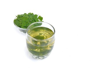 Boiled moringa leaves glass on white background. Healthy drink lifestyle, High angle view 