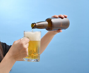 ジョッキにビールを注ぐ若い日本人女性の手