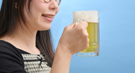 ジョッキに注がれたビールを持つ若い女性