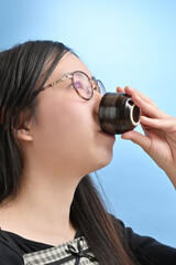 猪口で日本酒を飲む若い日本人女性