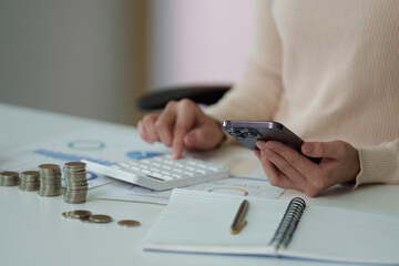 Financial Planning. Using a smartphone and calculator for budgeting.