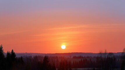 Obraz premium Serene Sunrise Over a Tranquil Landscape with Silhouetted Trees and Soft Sky Colors