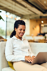 African-American Woman Working on Laptop in Modern Office Lounge