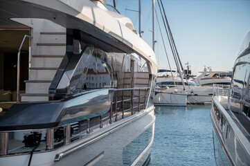 Luxury yachts docked side by side in a calm marina—modern white boats with sleek designs, teak decks, and comfortable seating areas at Limassol Marina