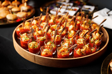 Mini shrimp appetizers in shot glasses with tomato sauce