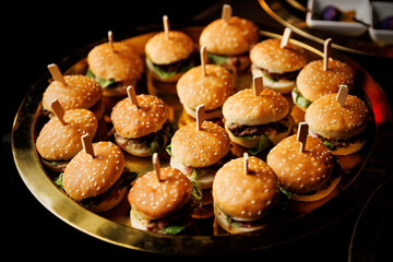 Tray of sesame seed mini burgers with wooden skewers