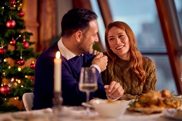 Couple Enjoying Christmas Dinner By Tree And Candlelight During A Warm, Festive New Year Celebration