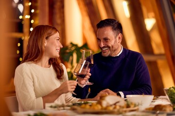 Couple Laughing Over Wine at Cozy Dinner, Warm Ambience and New Year Celebration