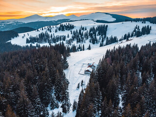 Winter landscape in the Carpathian Mountains, Romania. Snow-covered peaks, frozen forests, and a peaceful mountain valley