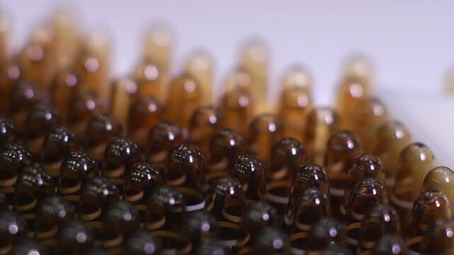 High-definition footage of an automated cleanroom assembly where glass ampoules are washed, filled with injectable medication, sterilized, and hermetically sealed. Showcases precision robotics, strict