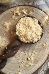 Whey protein powder on a wooden spoon on a table