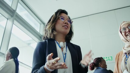 Group of diverse professional women engaged in discussion and networking at a business conference. They are smiling and actively participating in the event. - Powered by Adobe