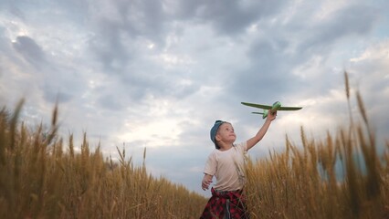 A kid runs toy airplane through a field of wheat. Happy family kid dream concept. A boy and a child are eating wheat on a plane toy airplane. A boy runs across a field lifestyle of wheat with a plane.