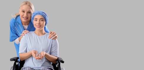 Doctor and young woman after chemotherapy holding awareness ribbon on grey background with space for text. Brain cancer concept