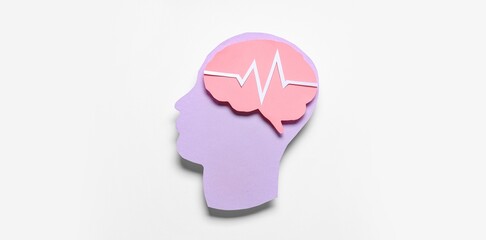 Paper human head and brain with cardiogram on light background