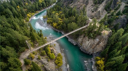 An aerial view showcases a turquoise river winding through a lush, tree-filled canyon, with a pedestrian suspension bridge