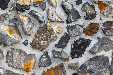 Close-up of Volcanic Rock Wall Texture with Lichen and White Mortar in Santorini, Greece. 6 October 2025