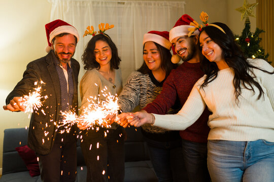 Diverse friends celebrating christmas holiday with sparklers