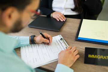 Man completing visa application form with immigration lawyer