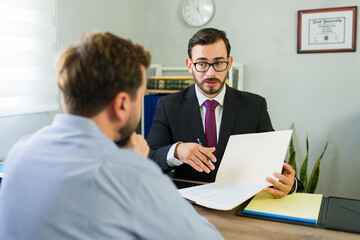 Lawyer advising client during formal office meeting