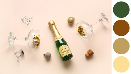 Bottle of champagne with glasses, Christmas balls, cork and confetti on beige background