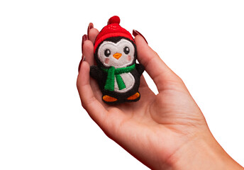 A Christmas penguin decoration in a woman's hand. Christmas decoration isolated transparent. Christmas. Xmas