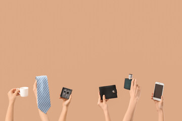 Young women holding men's tie, cup of coffee, mobile phone, bottle of perfume, wallet, box with tie...