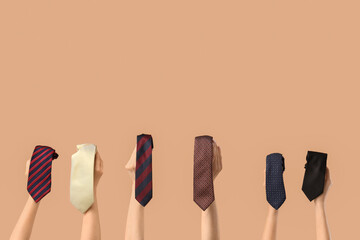 Female hands with different men's ties on beige background