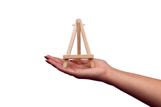 A hand holding a small wooden photo easel. Woman holding a small wooden paint easel. Small wooden easel isolated transparent - Powered by Adobe