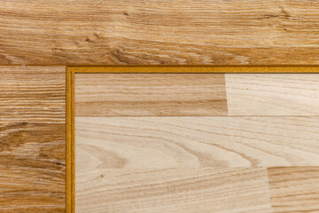 Wood laminate flooring installation on blue underlay during home renovation process