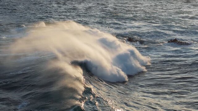 Huge power ocean wave crashing in morning sunlights. Slow motion of stormy ocean surf splashing on the coast of Madeira, Porto Moniz