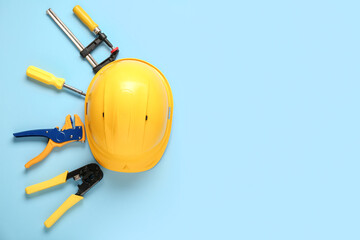 Yellow hardhat and construction tools on blue background