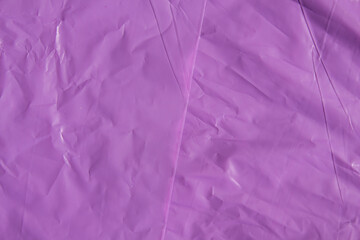 Bright purple plastic wrap sheet surface with creases and folds background