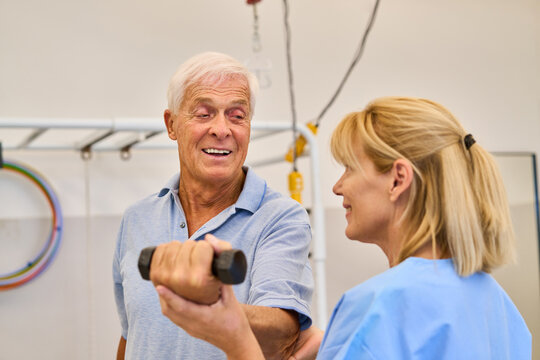Senior man in rehabilitation therapy assisted by healthcare professional