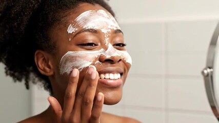 Black woman applying a face mask for a beauty self-care routine - Powered by Adobe