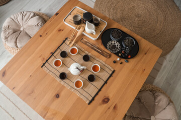 Chinese tea ceremony set with hot beverage in cups on table in room