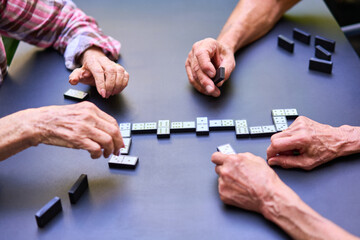 Seniors playing a game of dominoes on a table