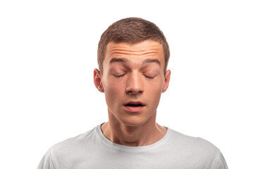 Obraz premium A young man with short brown hair and a white t-shirt stands with his eyes closed and mouth slightly open against a white background.