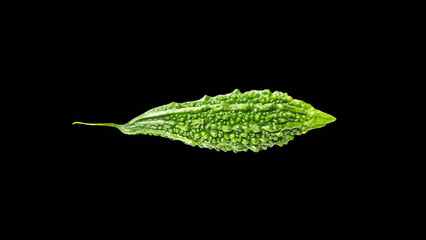 heap of bitter melon or momordica with leaves isolated on black background.