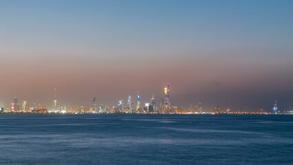 Obraz premium Skyline with Skyscrapers day to night timelapse in Kuwait City downtown illuminated at dusk. Kuwait City, Middle East