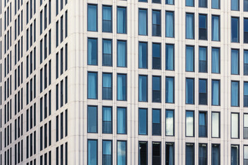 Fototapeta premium View of modern concrete glass metal high rise building facade exterior at day light time in Berlin Mitte city urban street. Business financial corporate office futuristic architecture