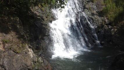 Fototapeta premium Majestic Waterfall Cascading Over Rocky Cliff Surrounded by Lush Greenery in Nature