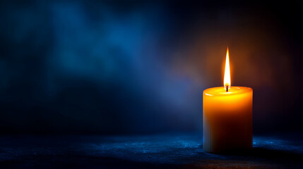 single candle burning isolated on navy blue background; candlelight in darkness as a grief, sorrow, all soul's day background