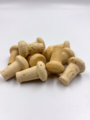 Macro photo showing a pile of natural cork stoppers on white background, organic structure visible.